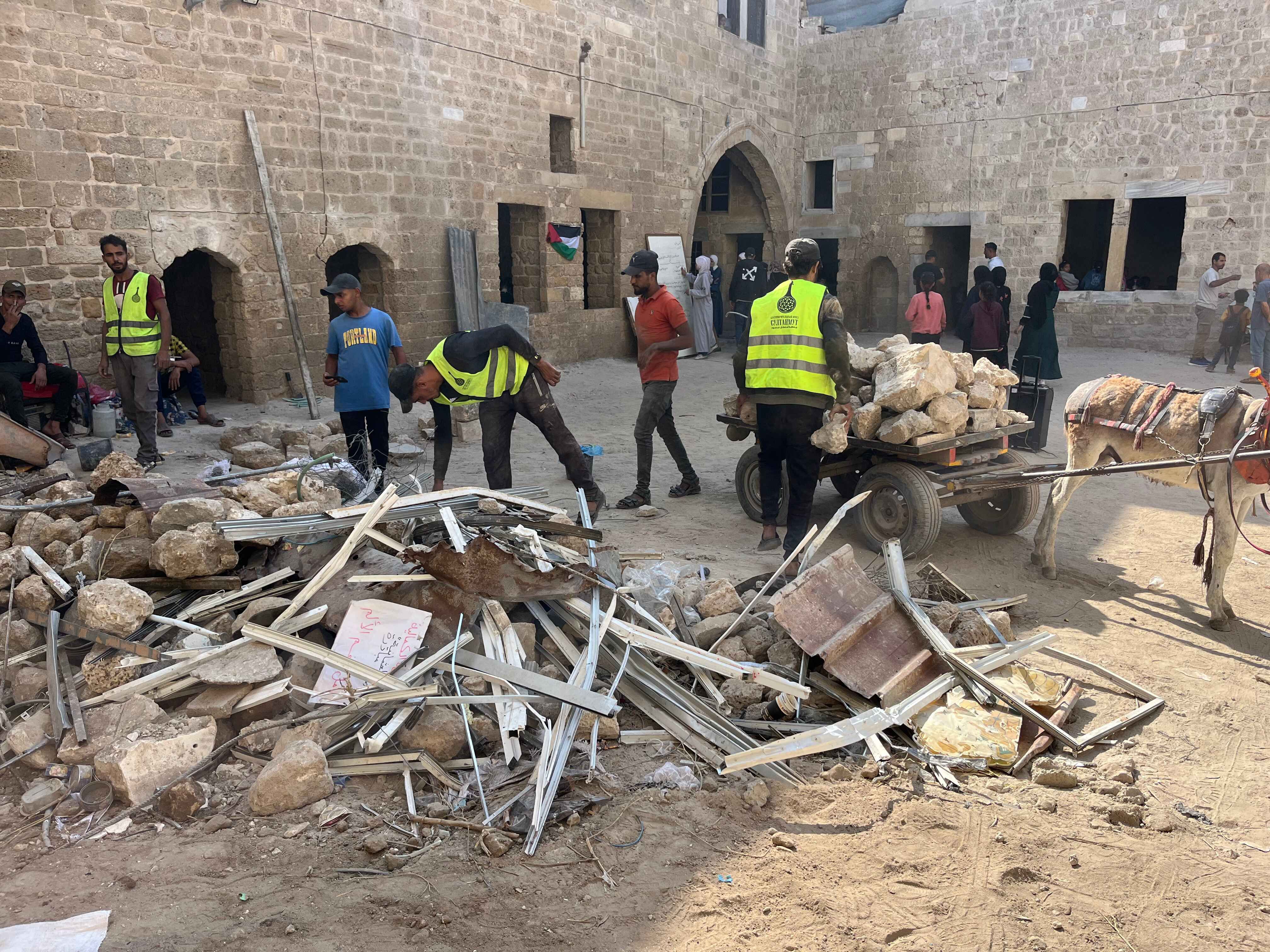 عمال يرفعون اثار الدمار في باحة المدرسة الكمالية في غزة. (النهار)