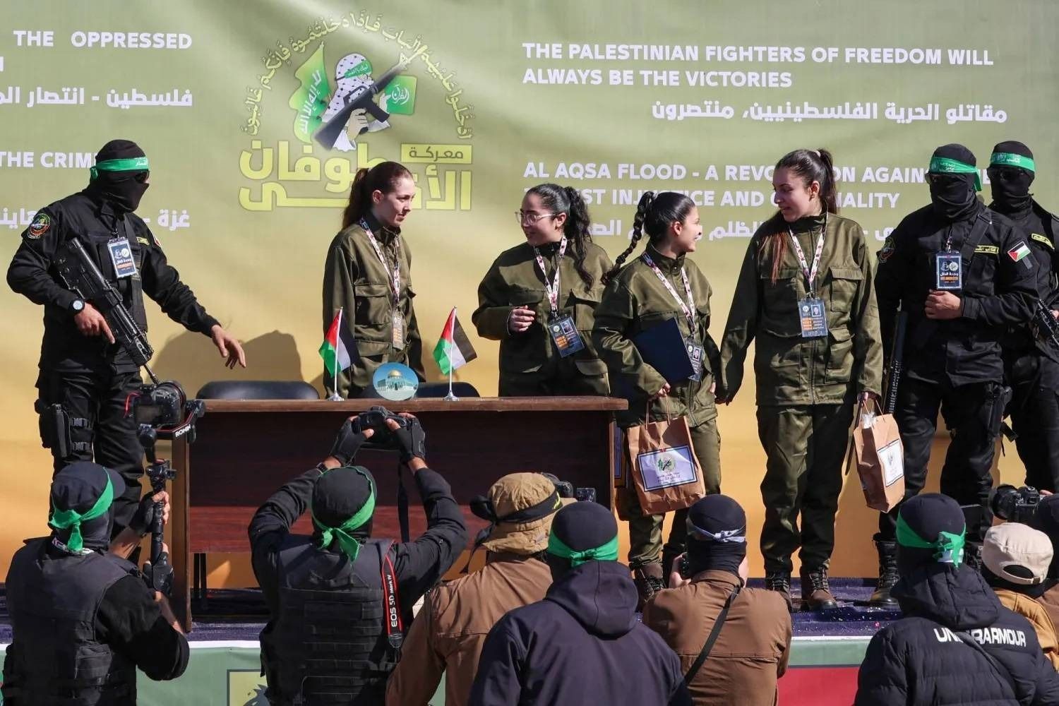 مقاتلو حماس مع 4 رهينات إسرائيليات قبل تسليمهن إلى فريق من الصليب الأحمر بمدينة غزة (أ.ف.ب)